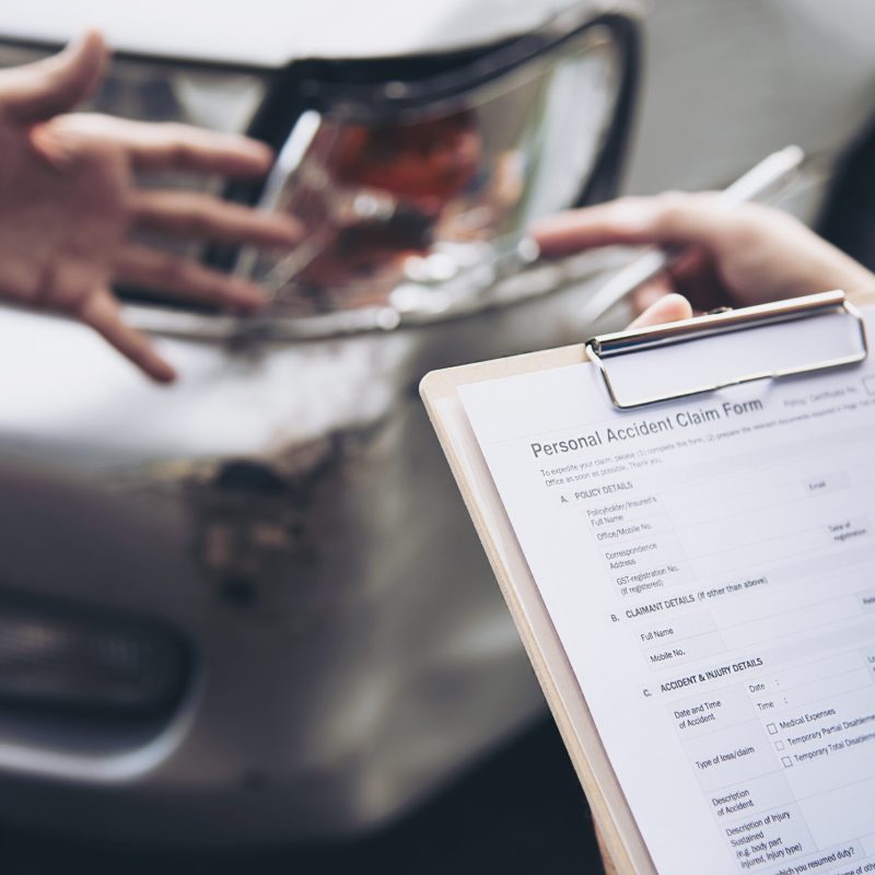 Insurance agent working during on site car accident claim process - people and car insurance claim concept